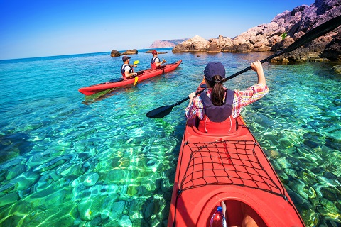 Kayaking. The woman floating on the sea kayak. Leisure activities on the sea. Canoeing.